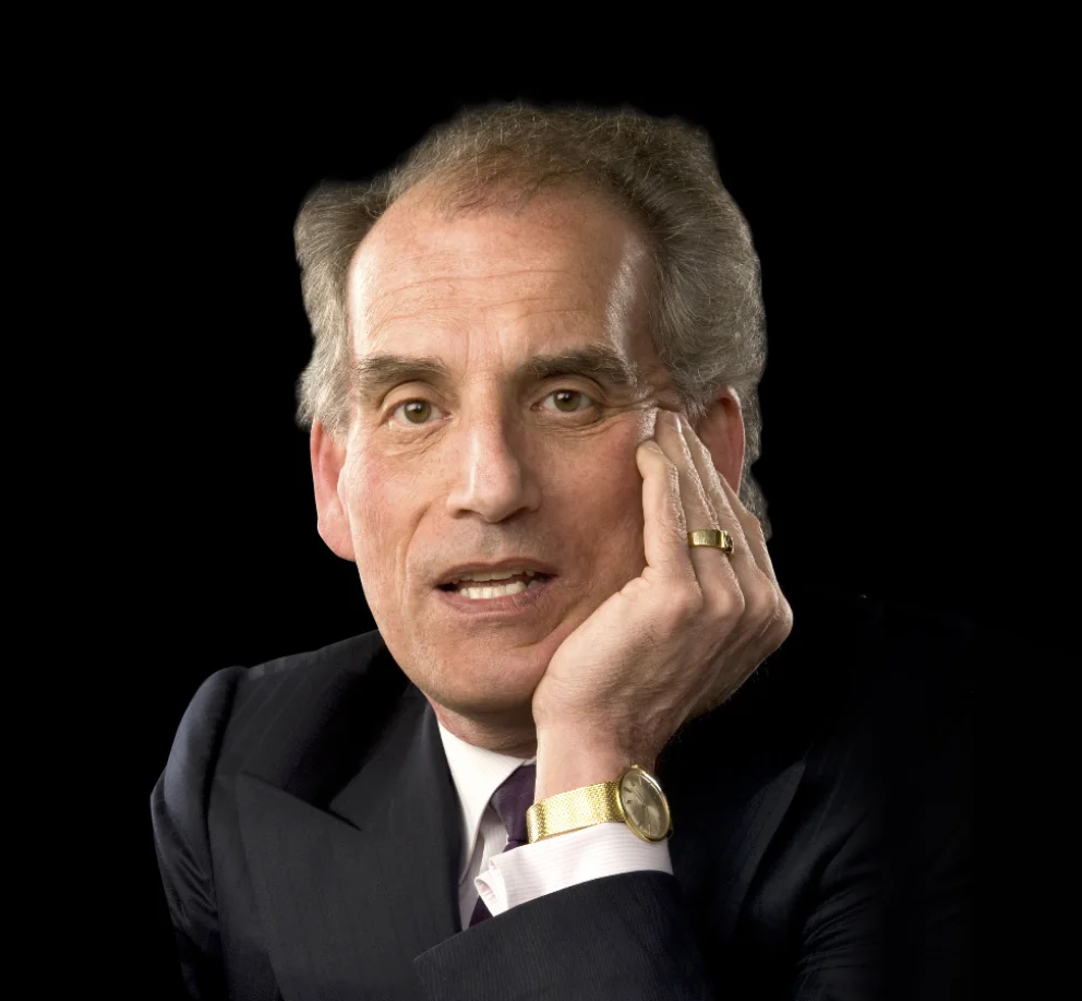 David Berlinski em retrato de estúdio, de terno escuro, com a mão apoiada no rosto.